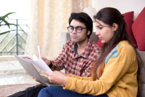 Young couple reading financial bill at home